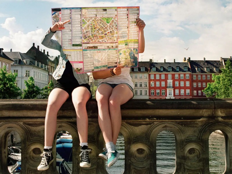 Zwei Teenager versteckt hinter einem gro&szlig;en Stadtplan.