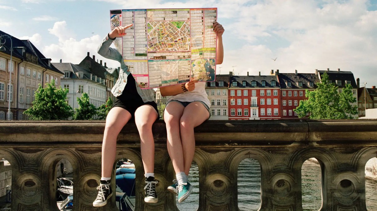 Zwei Teenager versteckt hinter einem großen Stadtplan.