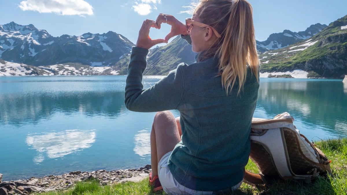 Frau sitzt auf einem Berg.