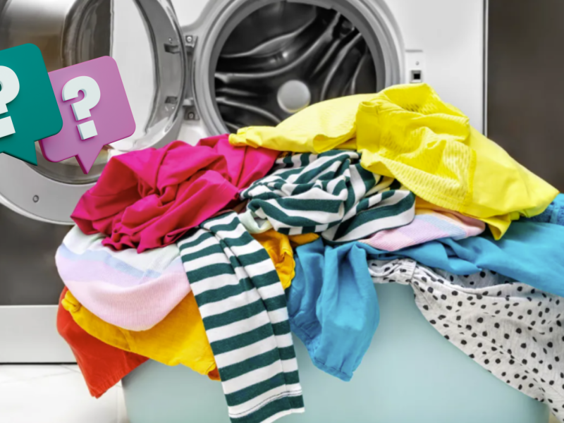 Korb mit bunter Kleidung vor einer Waschmaschine