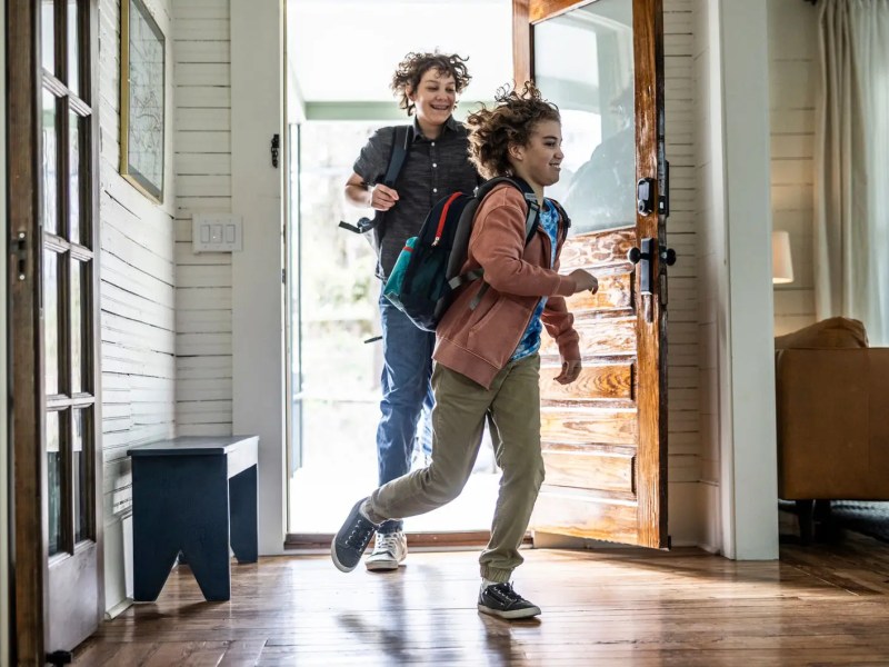 Zwei Jungs im Teenageralter kommen rennend nach Hause.