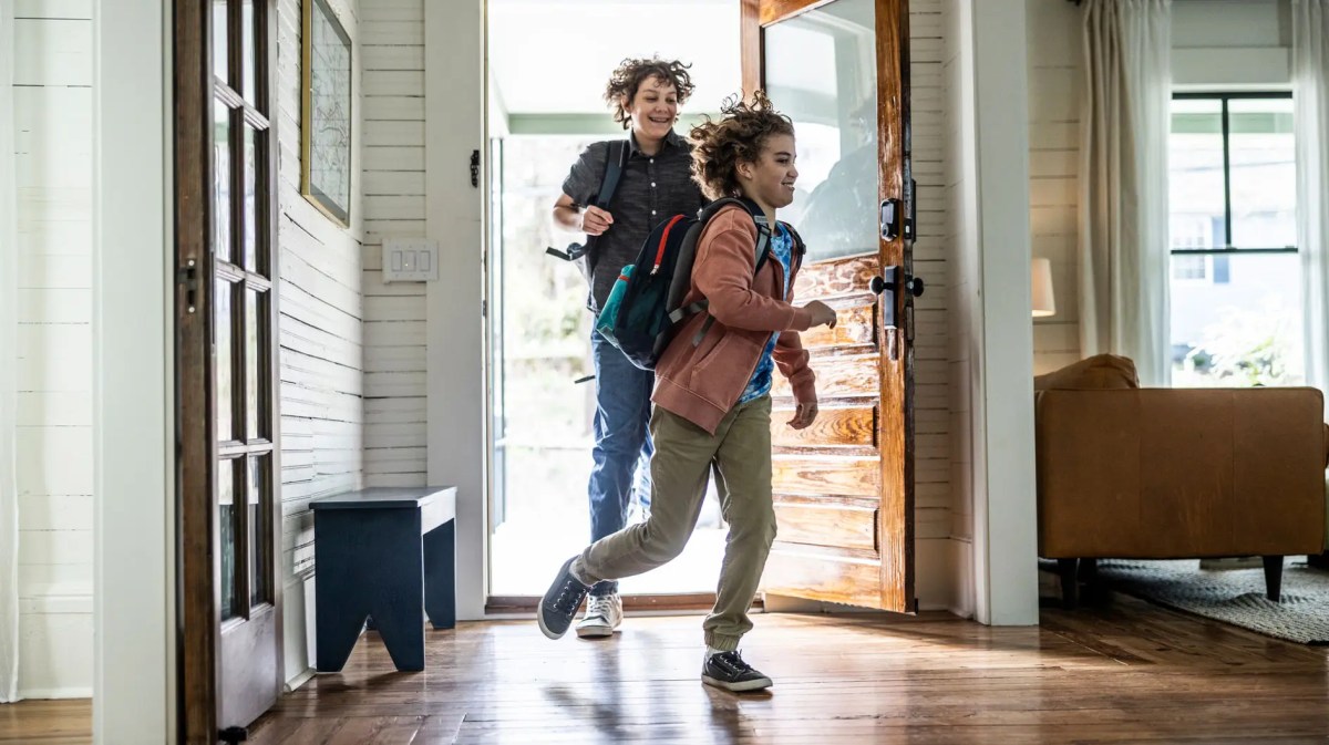 Zwei Jungs im Teenageralter kommen rennend nach Hause.