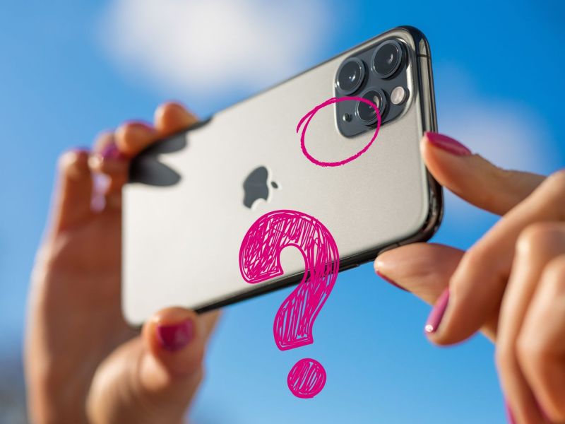 Frau hält Smartphone in beiden Händen, im Hintergrund blauer Himmel