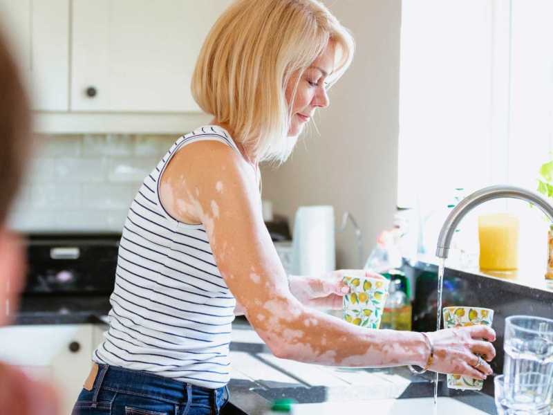 Frau wäscht Geschirr.