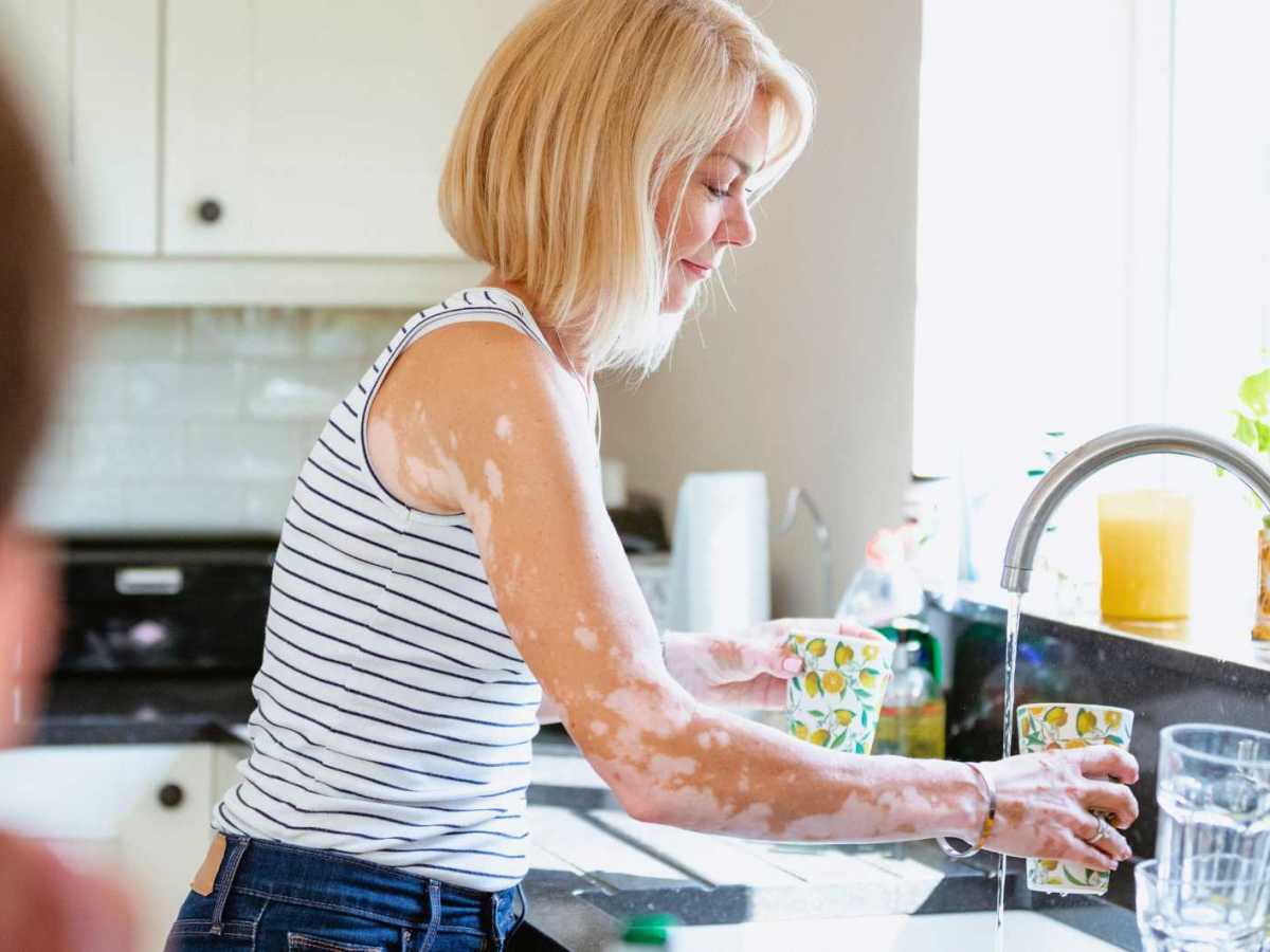 Frau wäscht Geschirr.