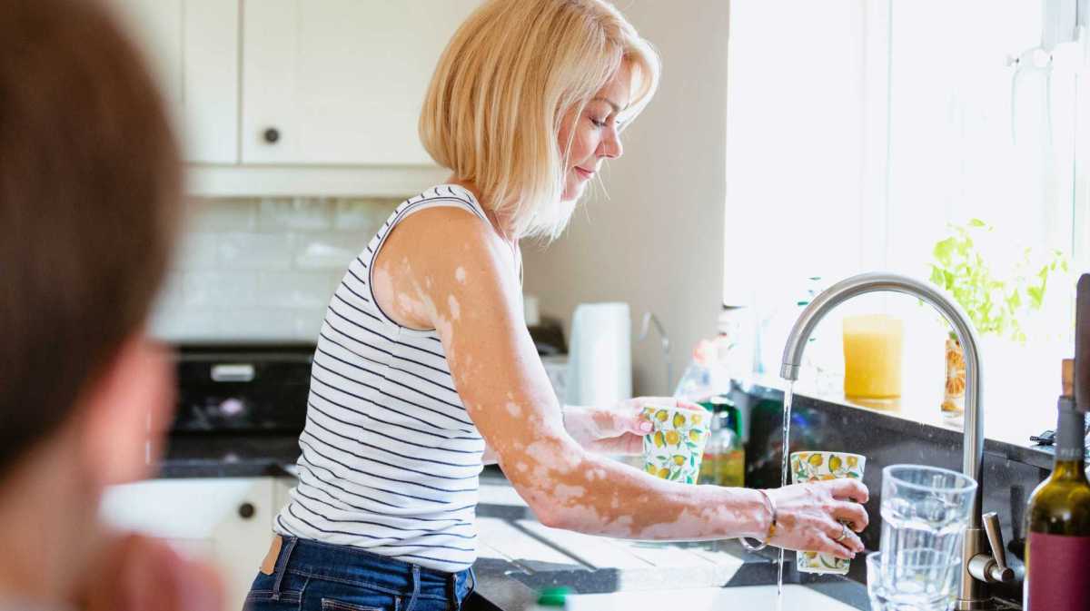 Frau wäscht Geschirr.