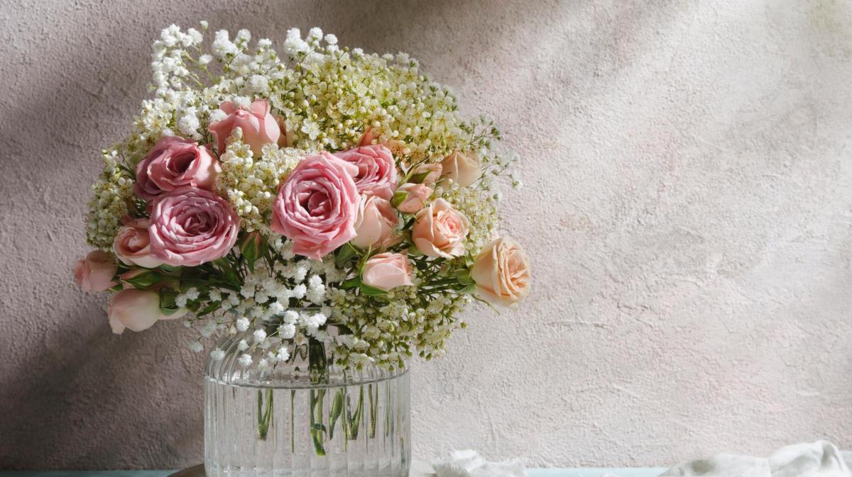 Blumenstrauß mit Rosen und Schleierkraut in einer Vase.