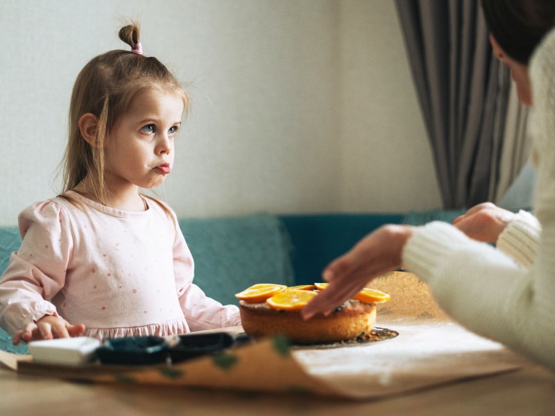 Mutter schimpft mit ihrer Tochter am K&uuml;chentisch zu Hause.