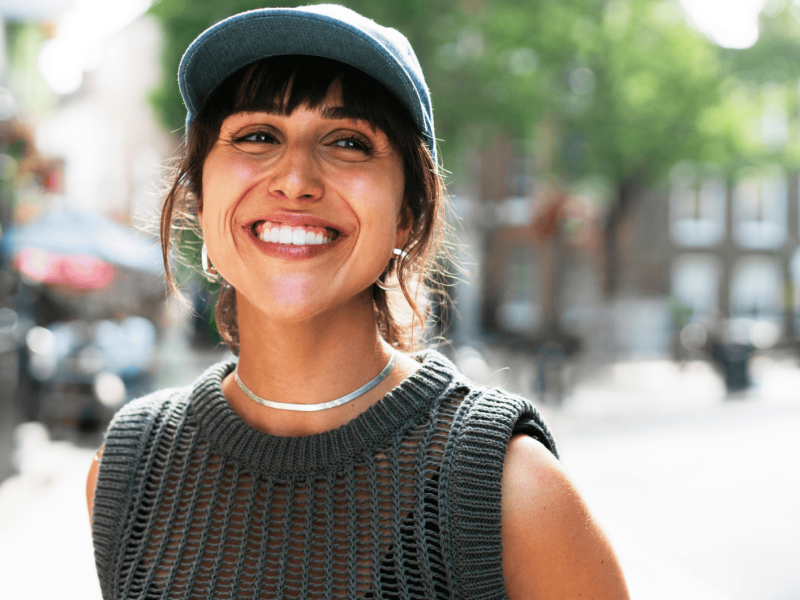 Junge Frau lächelt in Kamera.