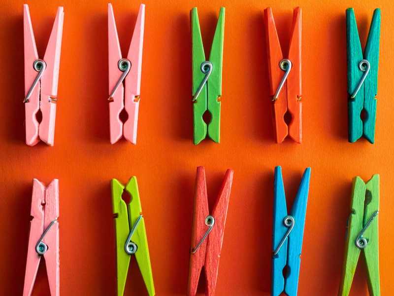 Bunte Wäscheklammern auf orangenem Hintergrund.