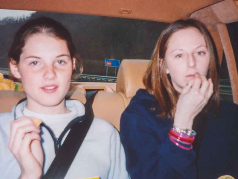Foto aus den späten 90er Jahren zweier Freundinnen auf dem Rücksitz eines Autos.