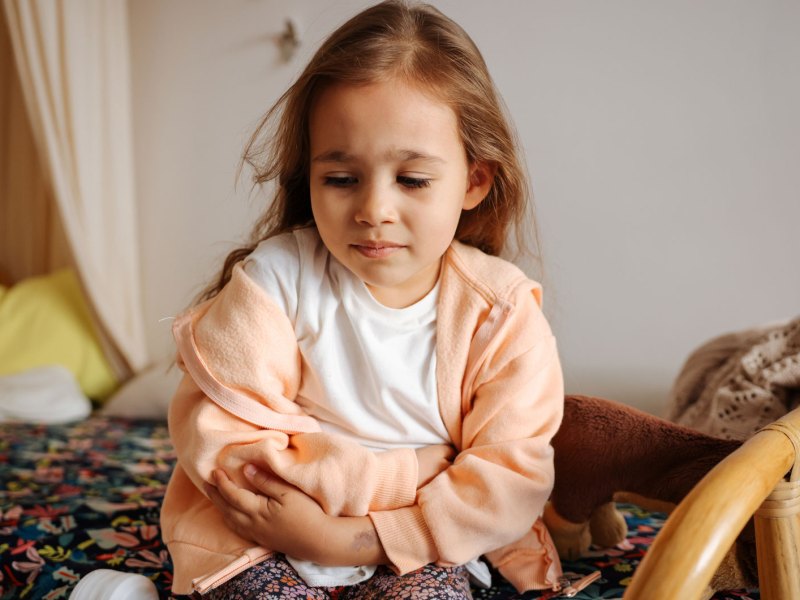 M&auml;dchen, ca. 6 Jahre alt, h&auml;lt sich den Bauch.
