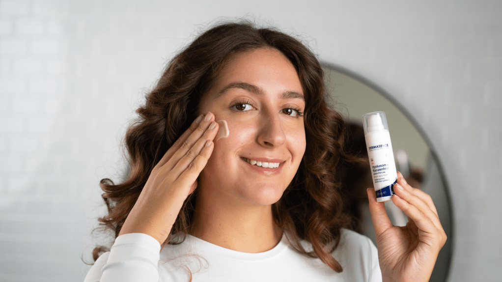 junge Frau cremt sich ihr Gesicht ein