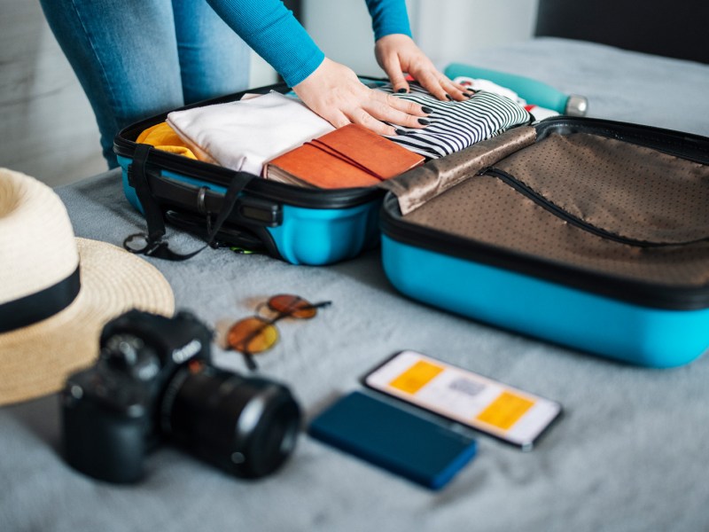 Frau beim Koffer packen und Sortieren.