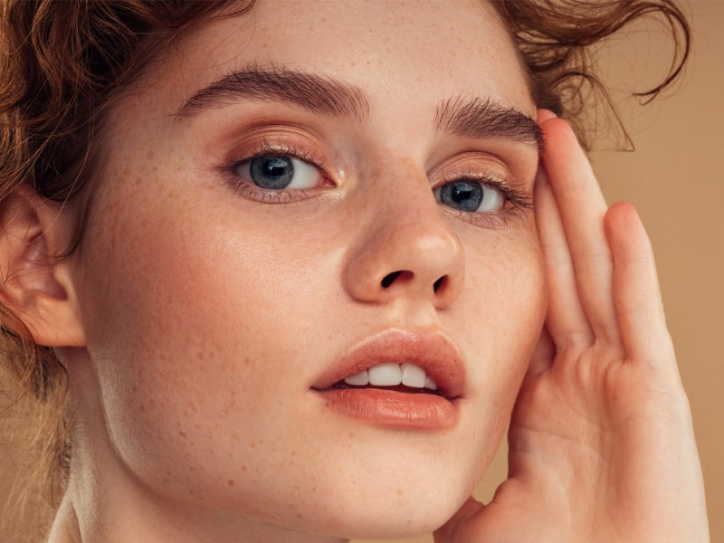 Frau mit rosigem Teint und vollen Augenbrauen.