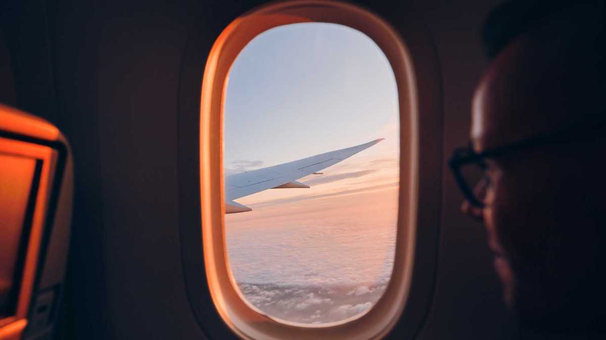 Mann schaut aus dem Flugzeugfenster