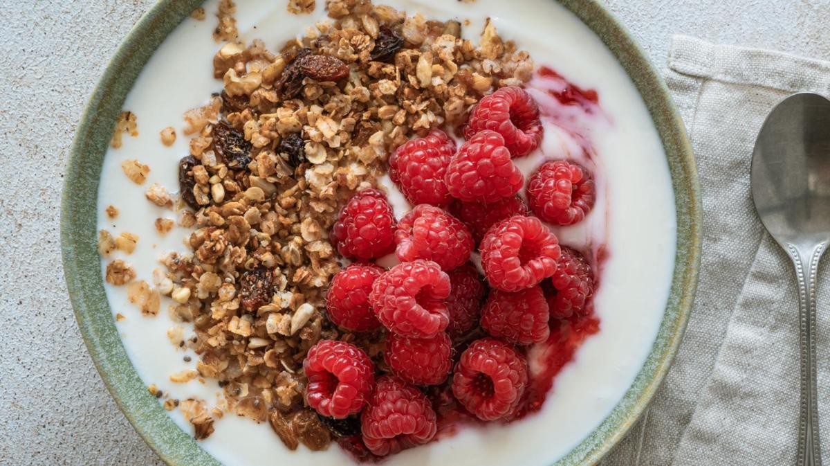 Bowl mit Skyr oder Joghurt und Granola und Himbeeren.