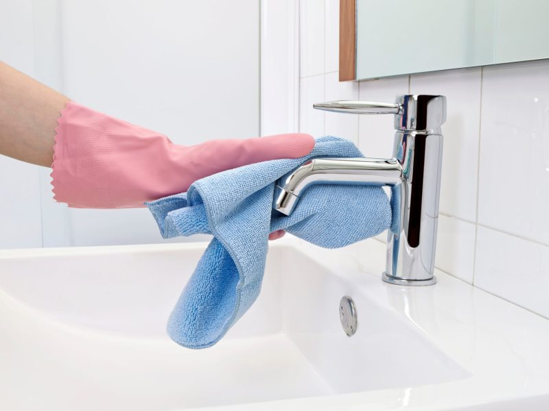 Frau putzt Badezimmer mit Tuch