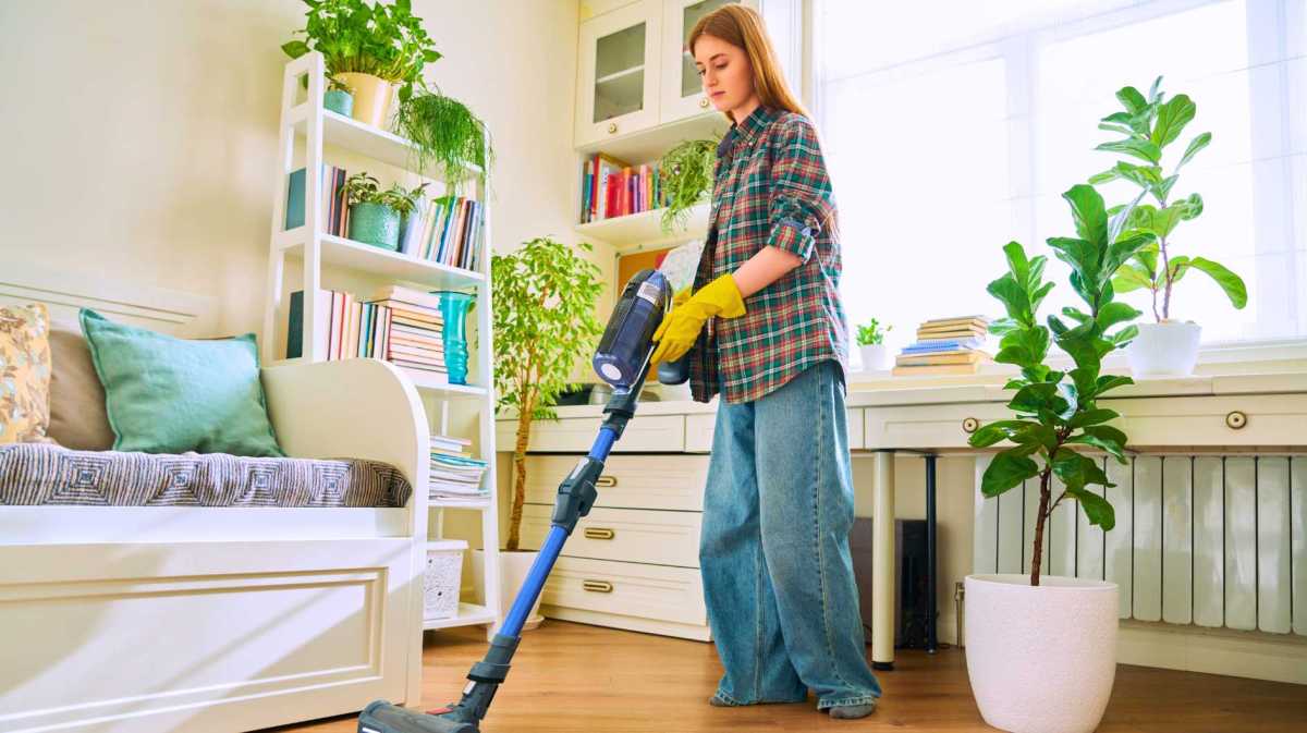 Frau saugt ihr Schlafzimmer.