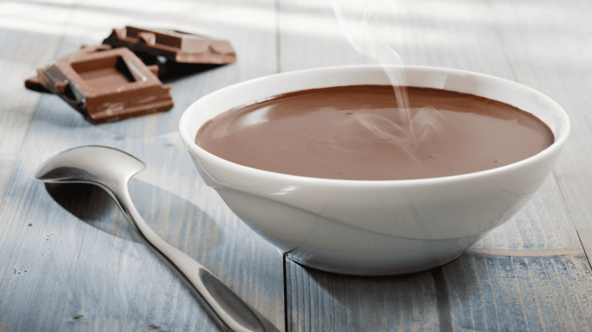 Eine weiße Schüssel mit dampfender Schokoladensuppe.