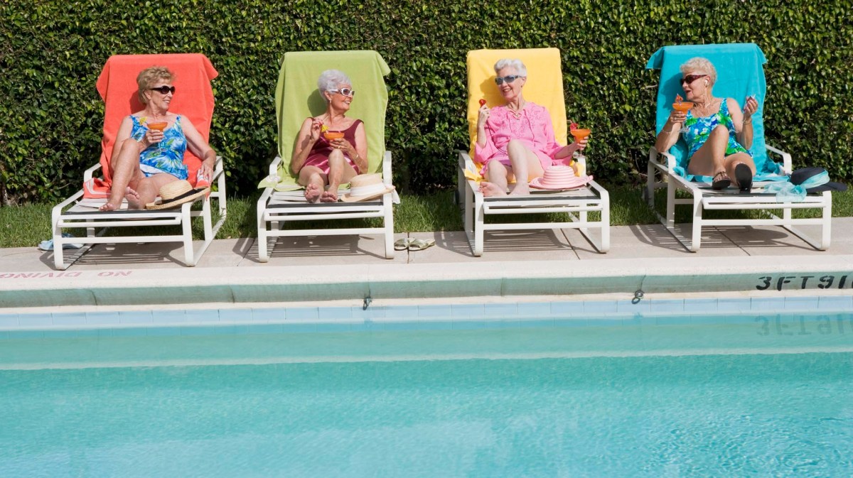 Seniorinnen liegen im Sommer an einem Pool