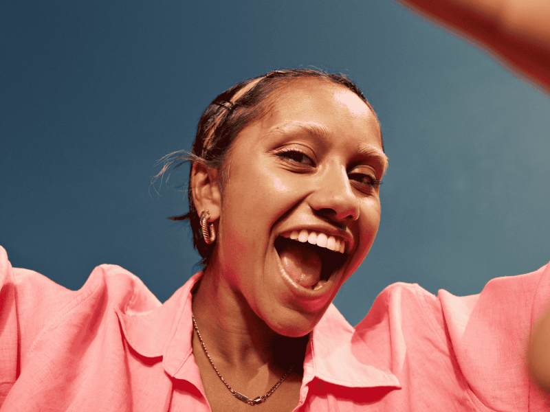 Junge Frau lächelt von oben in Kamera.