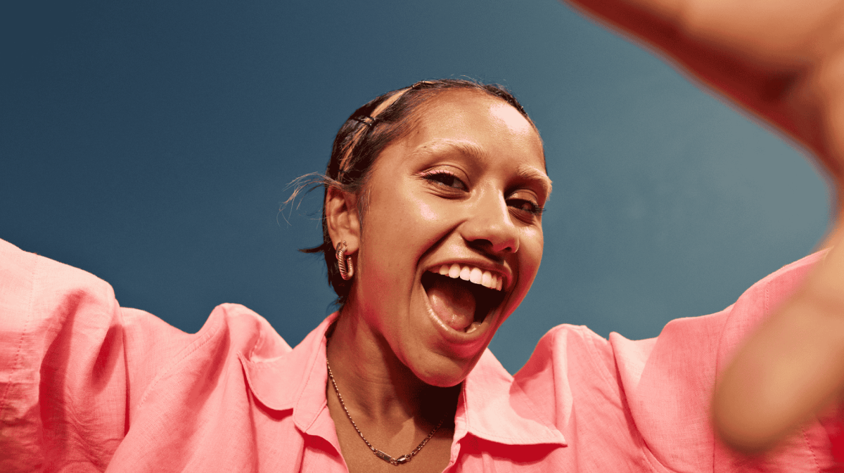 Junge Frau lächelt von oben in Kamera.