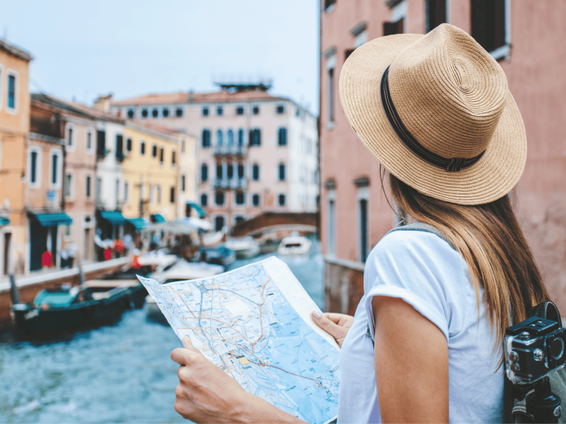 Frau mit Karte in Hand schaut sich Venedig an.