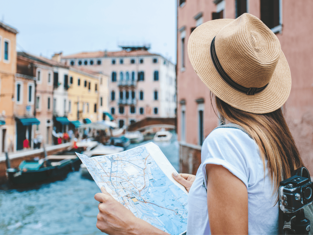 Frau mit Karte in Hand schaut sich Venedig an.