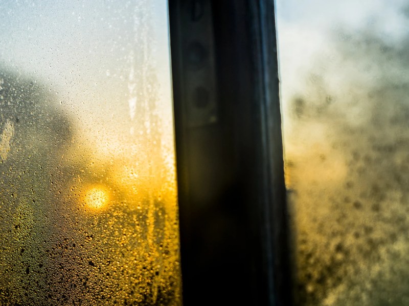 Beschlagene Fensterscheibe mit Abendsonne im Hintergrund