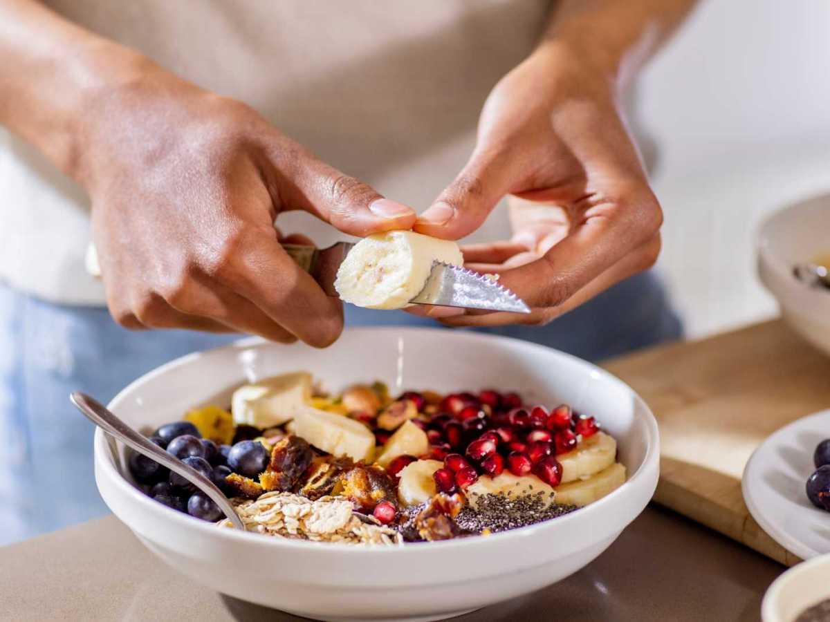 Nahaufnahme einer Frau, die sich einen gesunden Snack zubereitet.