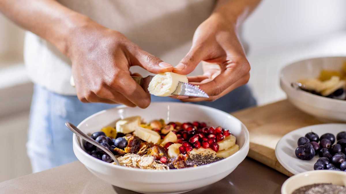 Nahaufnahme einer Frau, die sich einen gesunden Snack zubereitet.