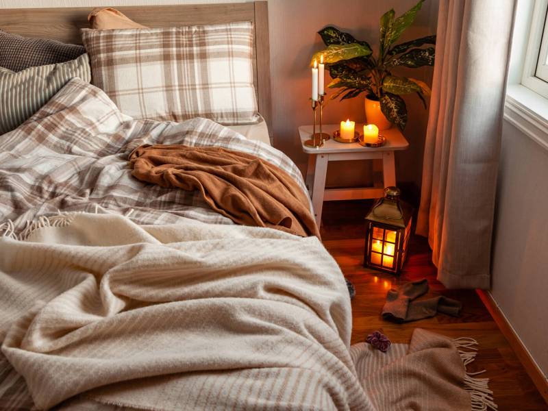 Gemütliches Herbst-Schlafzimmer mit Kerzen und Kuscheldecken
