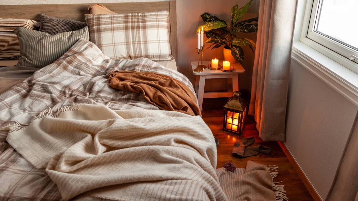 Gemütliches Herbst-Schlafzimmer mit Kerzen und Kuscheldecken
