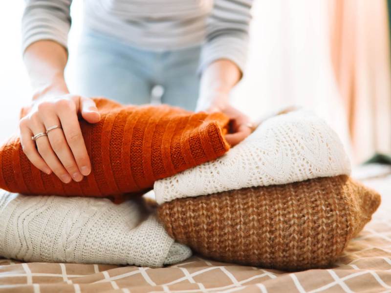 Frau legt Pullover zusammen