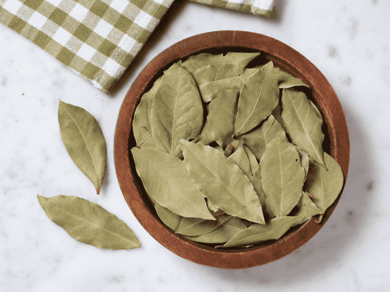 Getrocknete Lorbeerblätter in einer Holzschale.