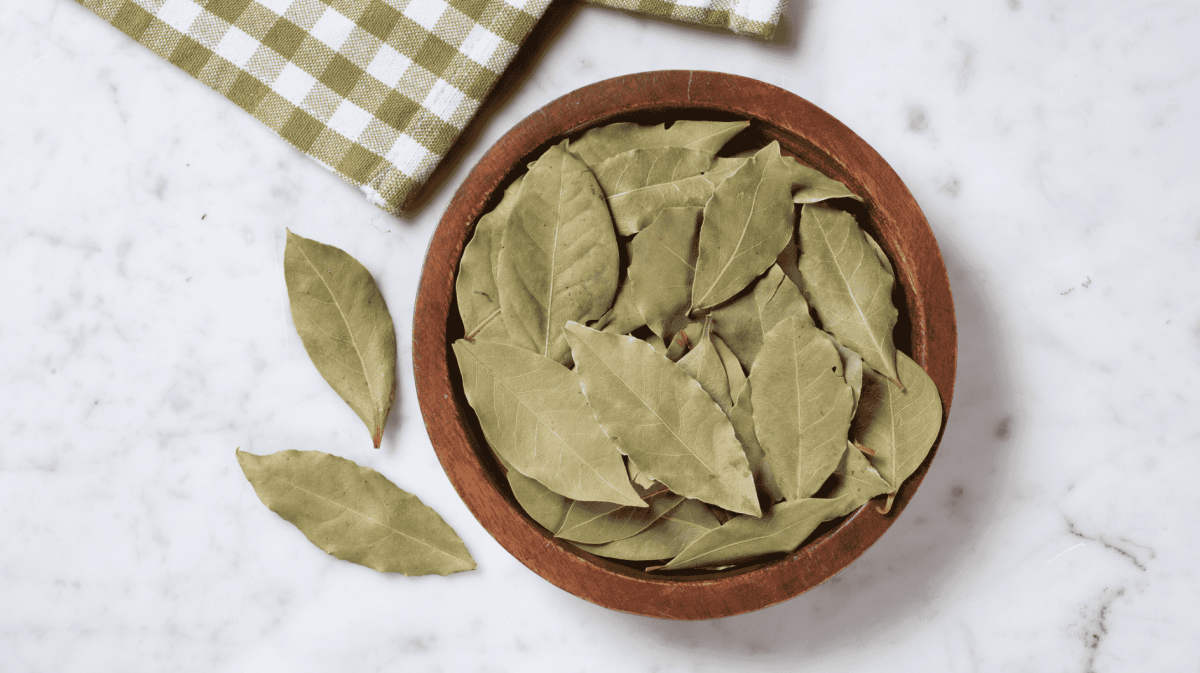 Getrocknete Lorbeerblätter in einer Holzschale.