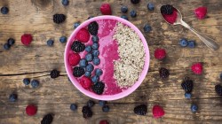 Schale mit Fruchtsmoothie, garniert mit Beeren und Hanfsamen