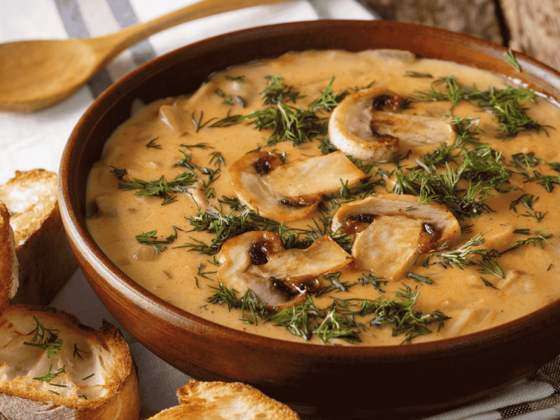 Cremige Pilzsuppe in einer braunen Schüssel.