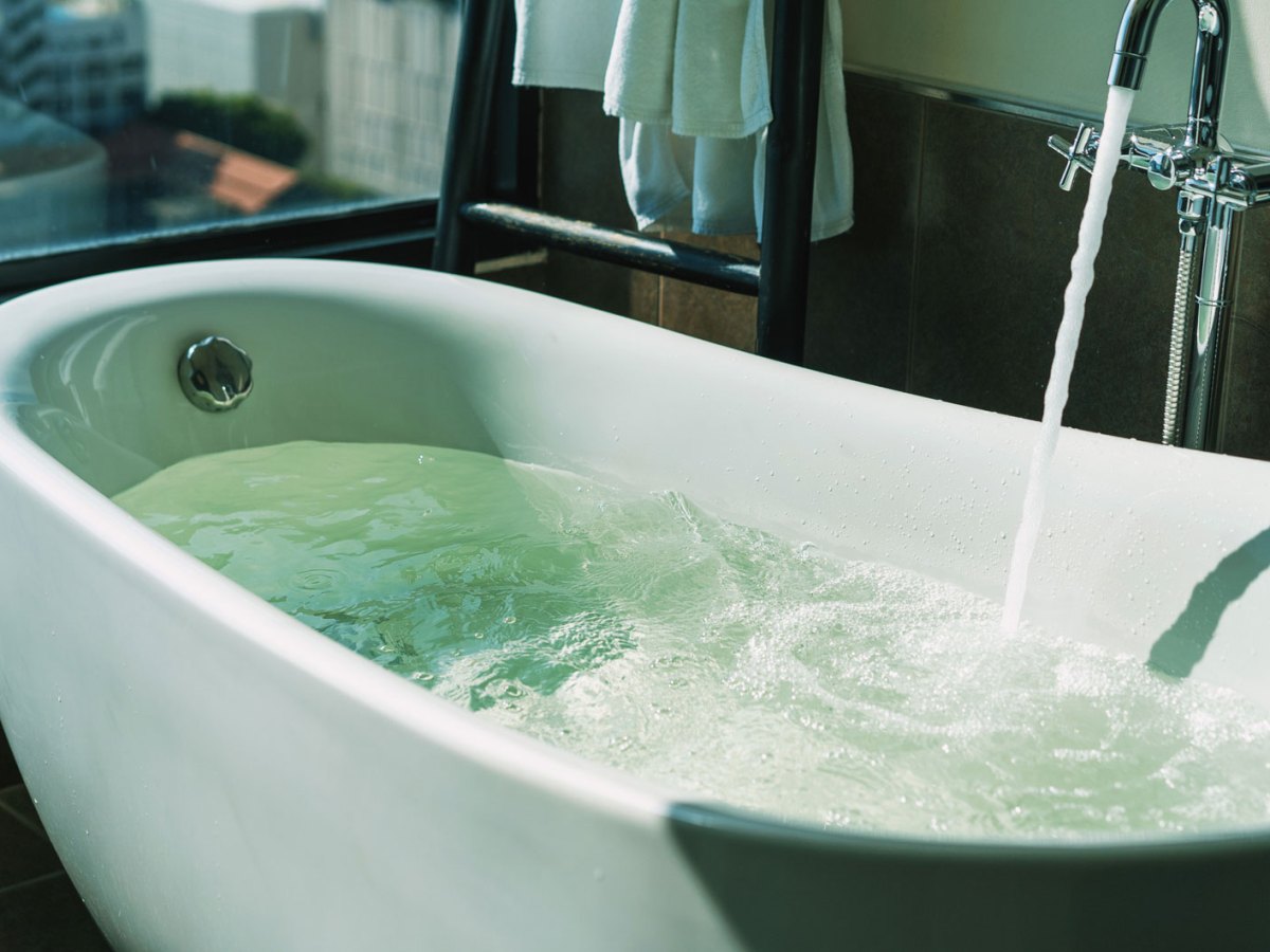 Badewanne, direkt am Fenster, in die Wasser einl&auml;uft.