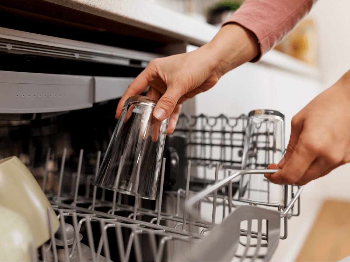 Frau r&auml;umt Geschirr ein.