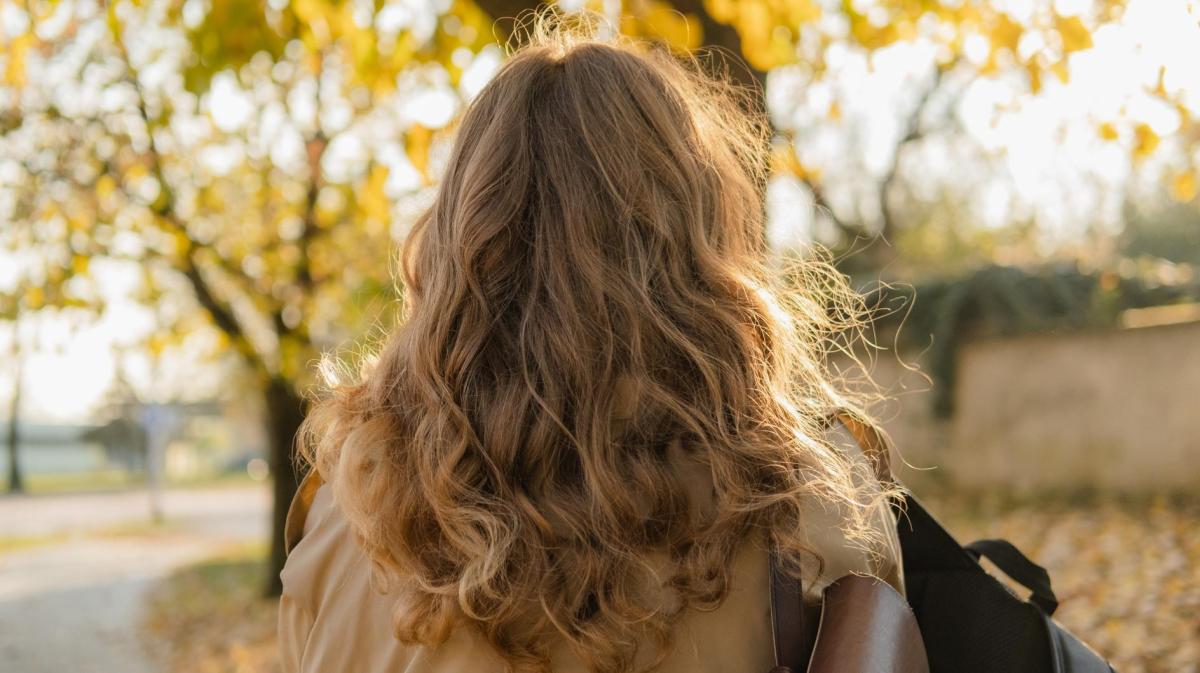 Leicht gewellte und lockige Haare einer Frau von hinten.
