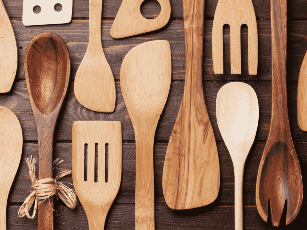 Mehrere Kochlöffel aus Holz auf einem Holztisch.
