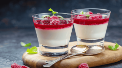 Panna Cotta mit Fruchtspiegel in zwei Gläsern.