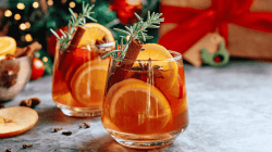 Winterliche Sangria mit Zimtstangen, Orangen und Rosmarin.