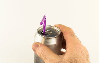 Die Dosenlasche hat eine Geheimfunktion Hand an Getränkedose, bei der in Lasche ein pinker Strohhalm steckt