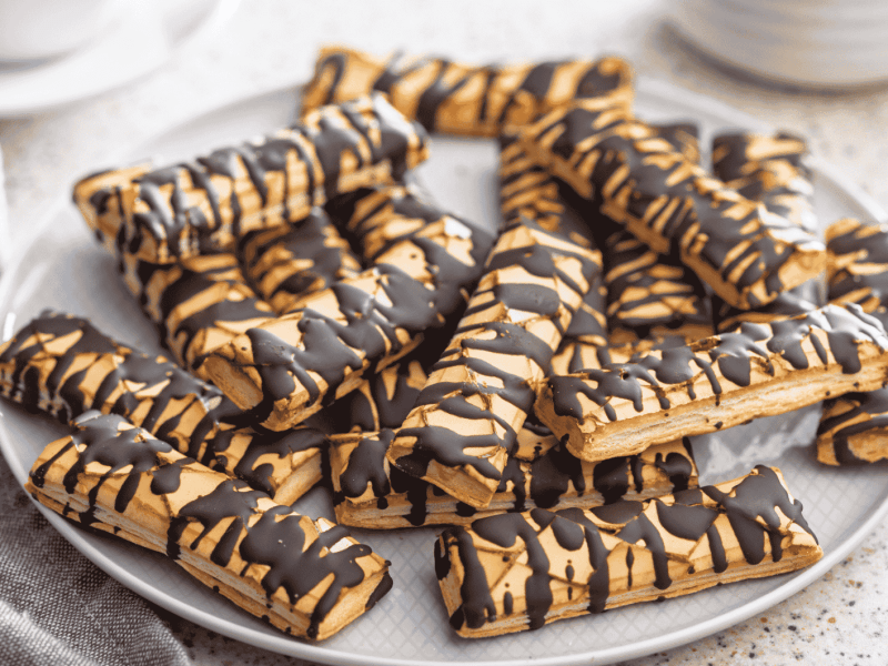 Sfogliatine glassate mit Schokoladen-Glasur auf einem Teller.