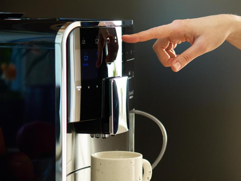 Person macht sich einen Kaffee mit einem Vollautomaten.