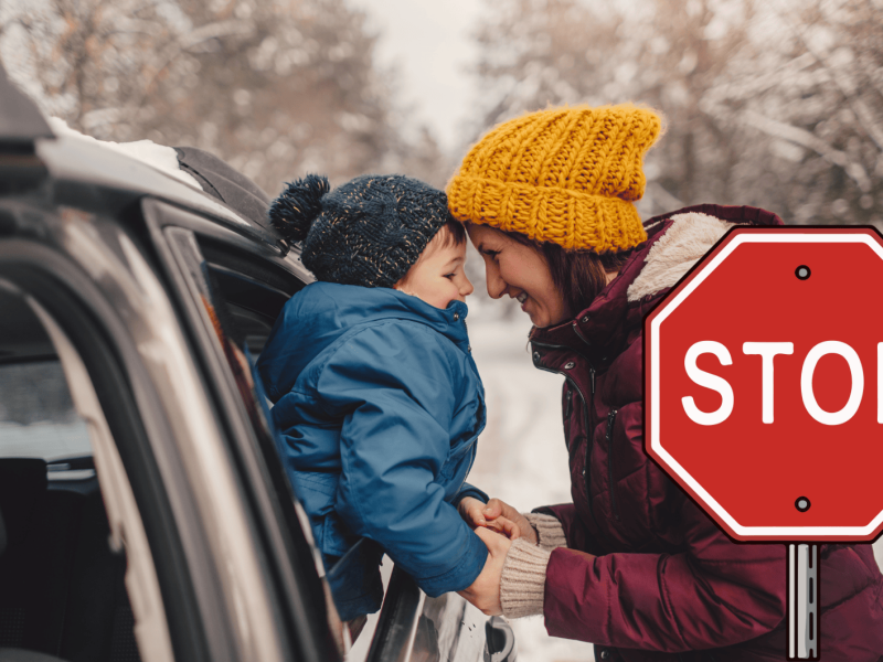 Frau und Kind tragen Winterjacke und stehen bei Schnee am Auto.