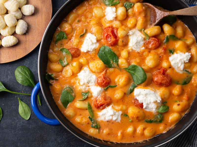 Gnocchi mit Baslikum, Tomatenso&szlig;e und K&auml;se in einem gro&szlig;en Topf.